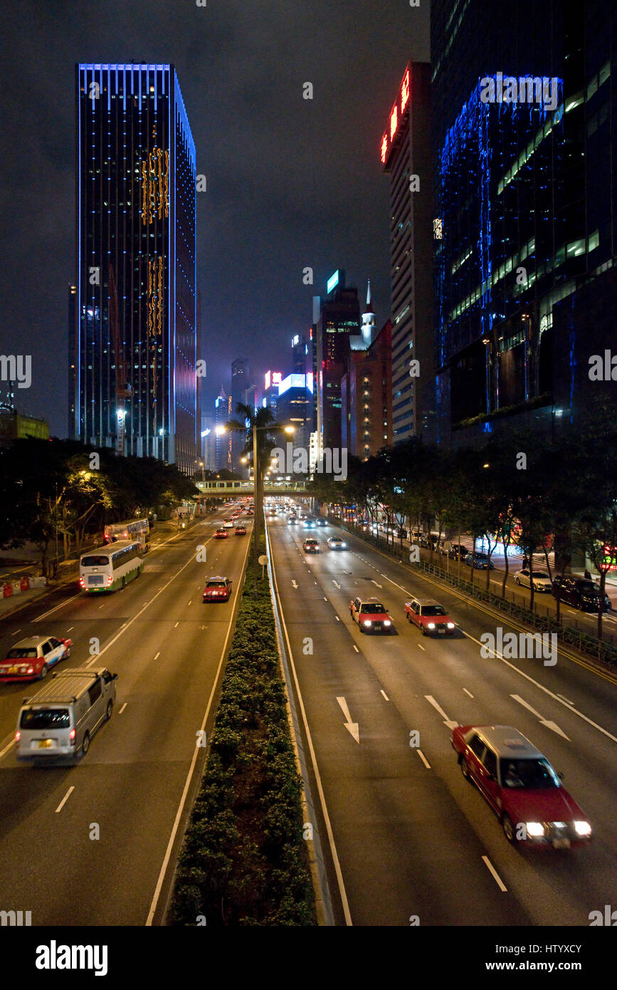 Una vista de los rascacielos y el tráfico con el desenfoque de movimiento a lo largo de Gloucester Road en la isla de Hong Kong en la tarde noche. Foto de stock