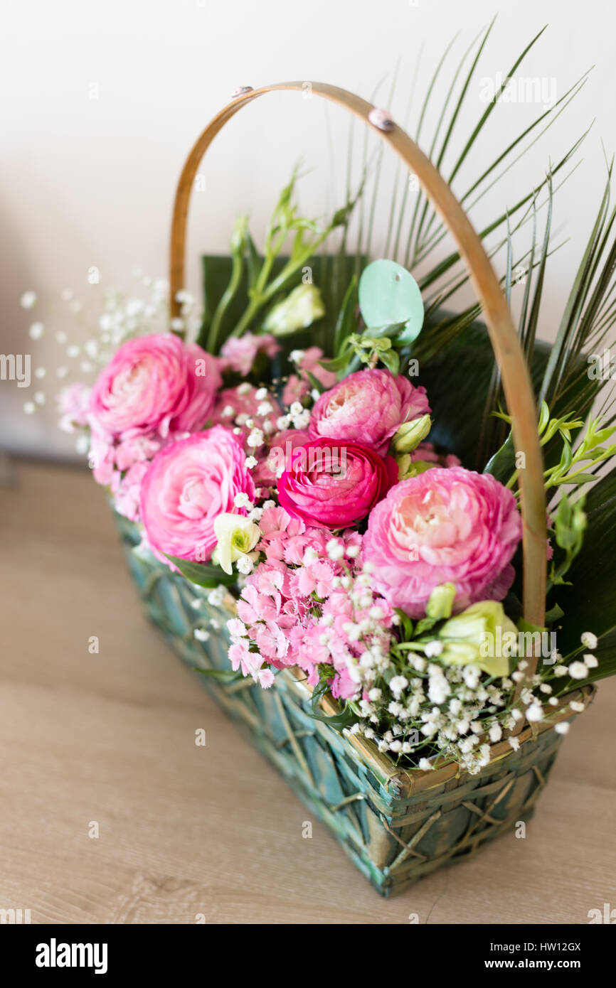 Arreglo floral en canasta con oscuridad y luz rosa ranúnculos y austeria  vista desde arriba con flores en foco central y otras flores borrosas  Fotografía de stock - Alamy