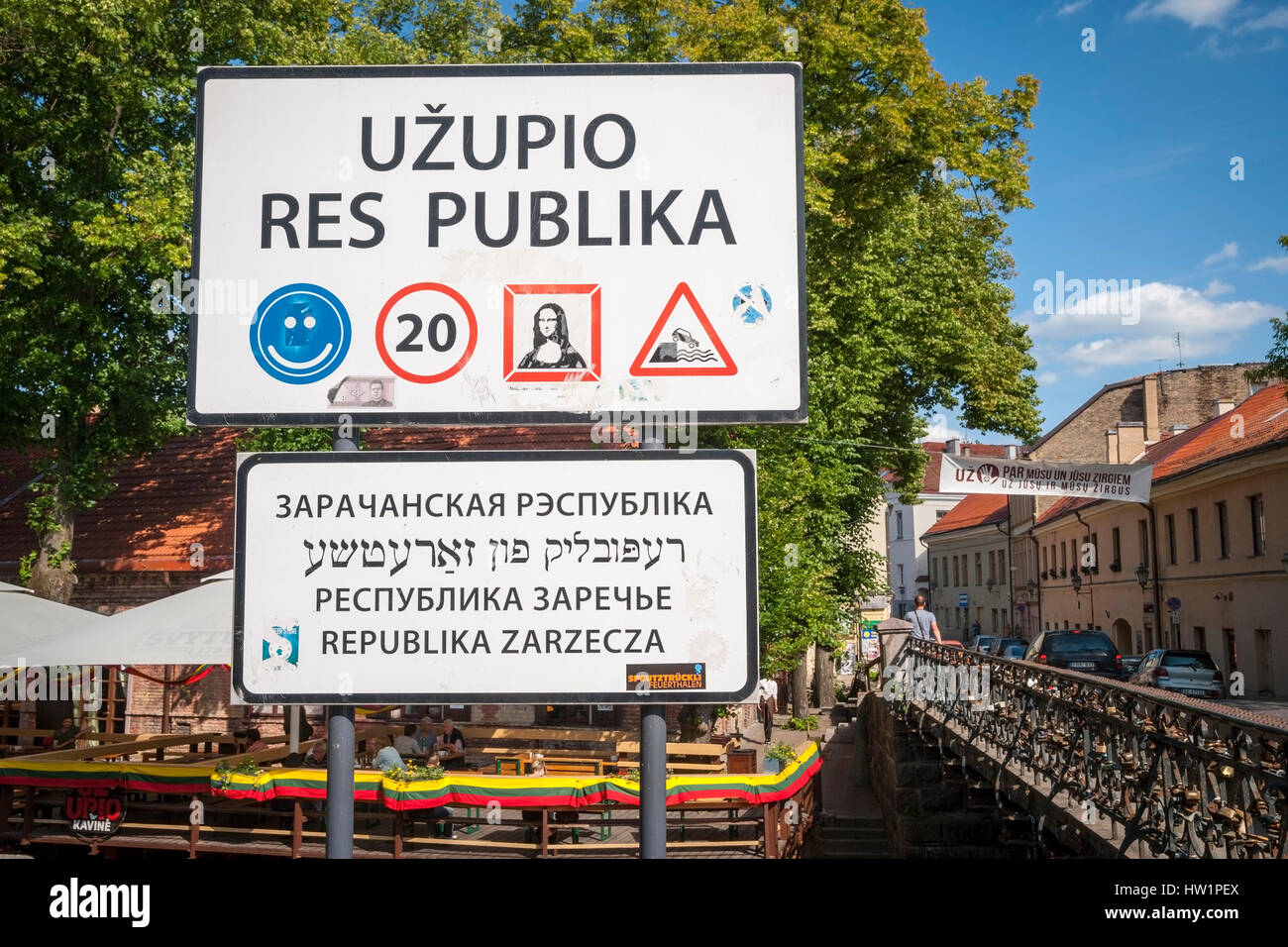 Señal de carretera lituana con texto en contra de árbol verde y cielo Foto de stock