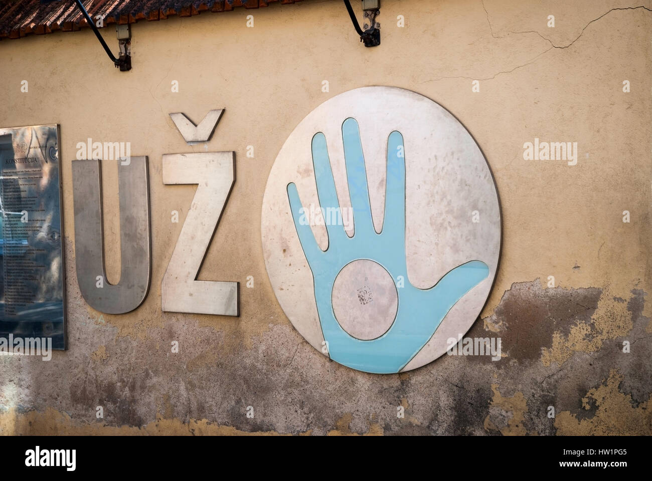 Azul con la mano en el círculo de metal en la pared agrietada. República Uzupis logo, Vilnius, Lituania Foto de stock