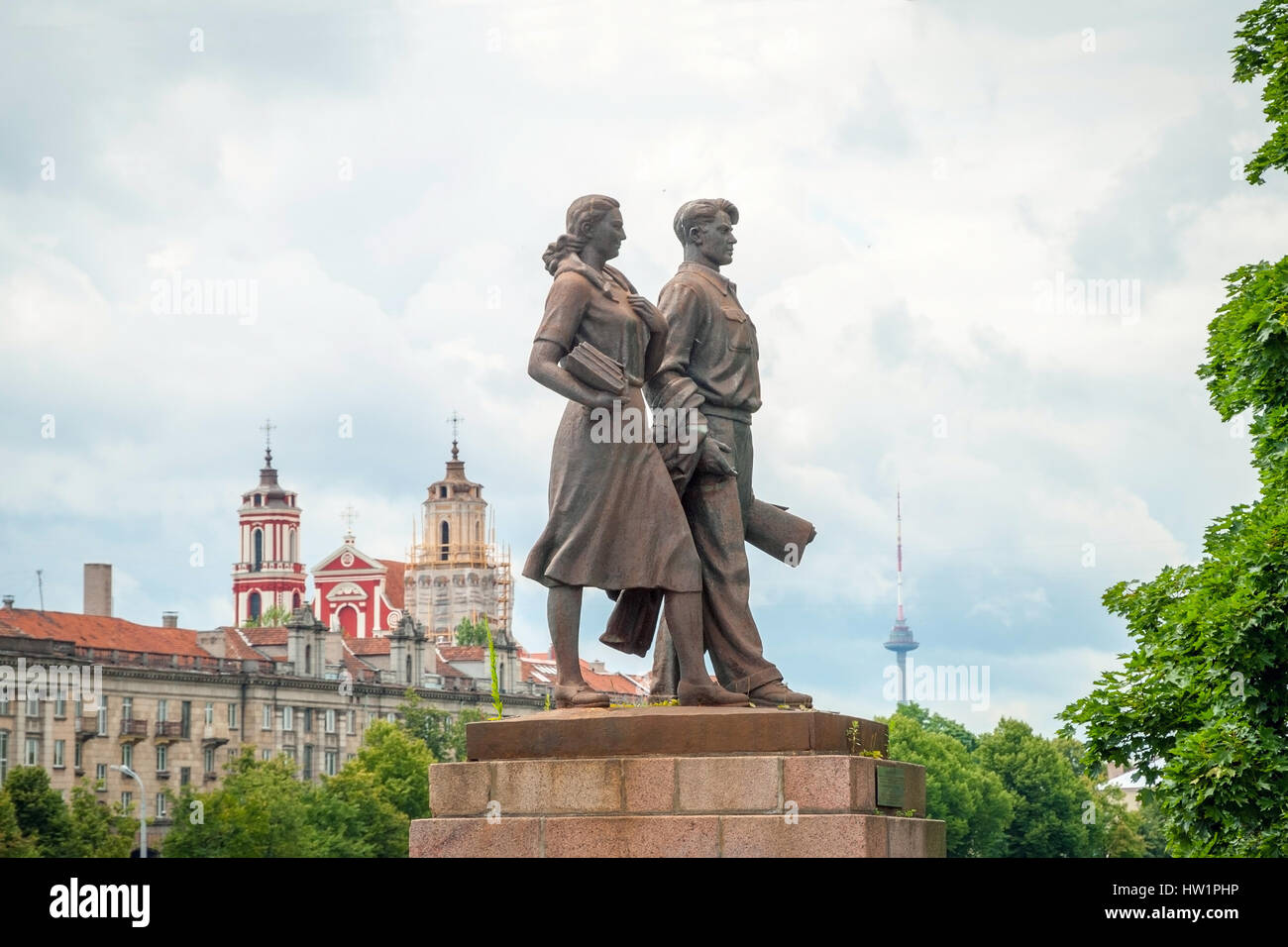Estatua de hierro de dos estudiantes con libros en contra de cielo nublado en Puente Verde en Vilnius Foto de stock