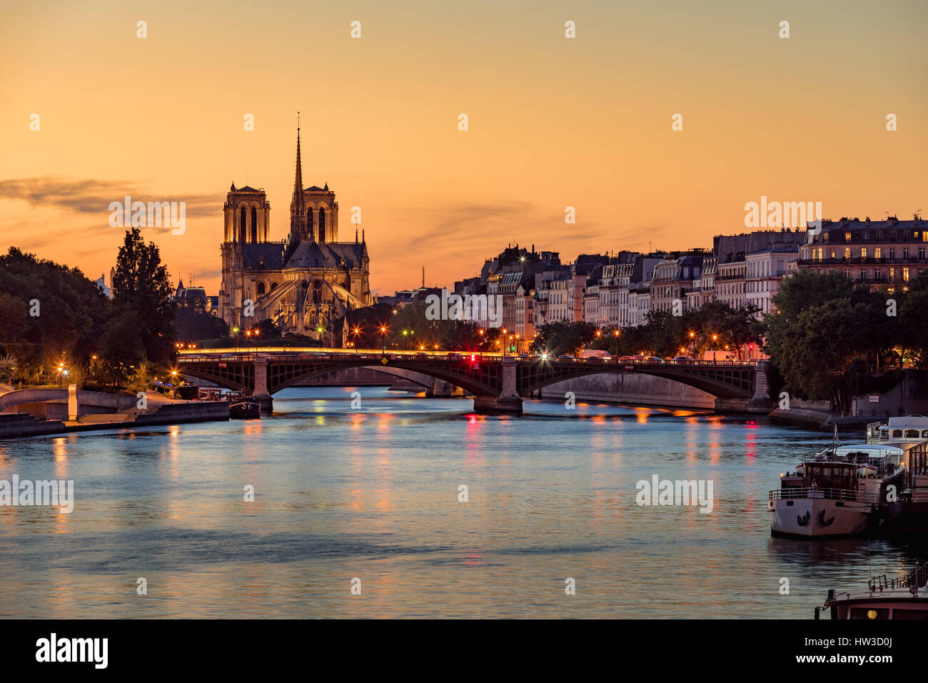 Catedral de Notre Dame, Ile Saint Louis y el Río Sena al atardecer. Noche de verano con el puente de Sully y las luces de la ciudad de París Foto de stock