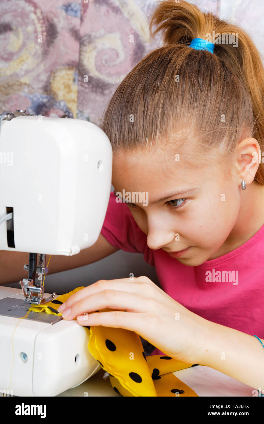 Chica aprende a coser en una máquina de coser eléctrica Fotografía de stock  - Alamy