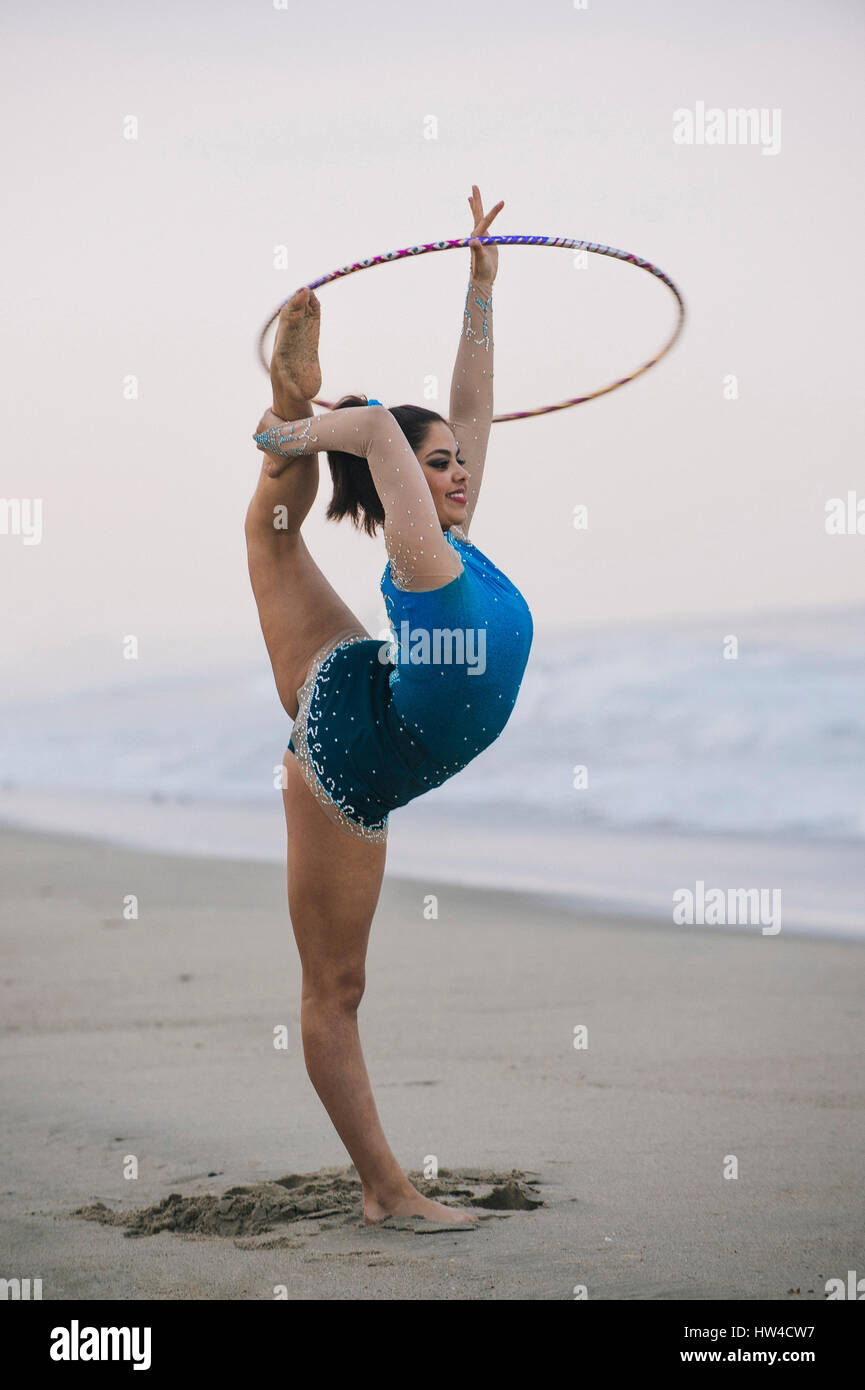 Gimnasta caucásica practicando con aro en la playa Foto de stock