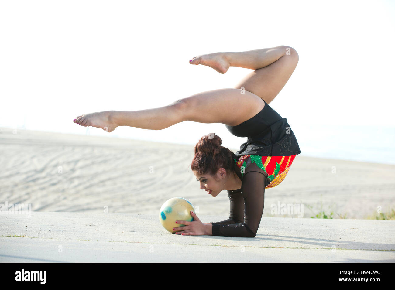 Gimnasta caucásica equilibrio sobre los brazos en la playa Foto de stock