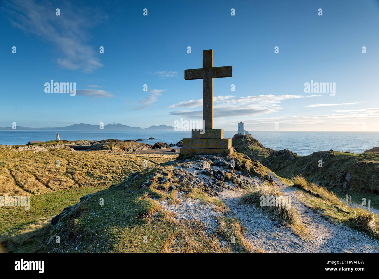 El faro y la cruz en la isla cerca de Newborough Llanddwyn en la costa de Anglesey en Gales Foto de stock