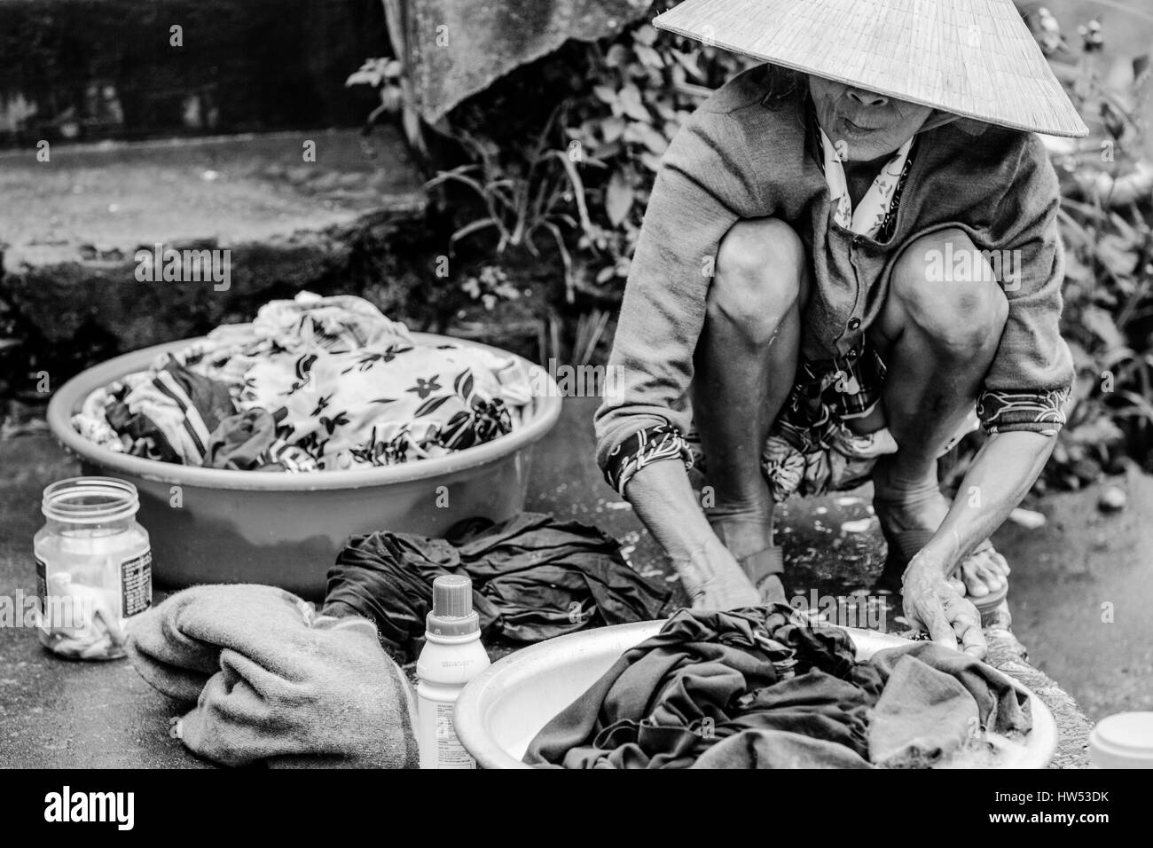 Hue, Vietnam - 9 Marzo, 2014: Old mujer vietnamita está lavando ropa en la orilla del río Perfume, el 9 de marzo de 2014, Hue, Vietnam Foto de stock