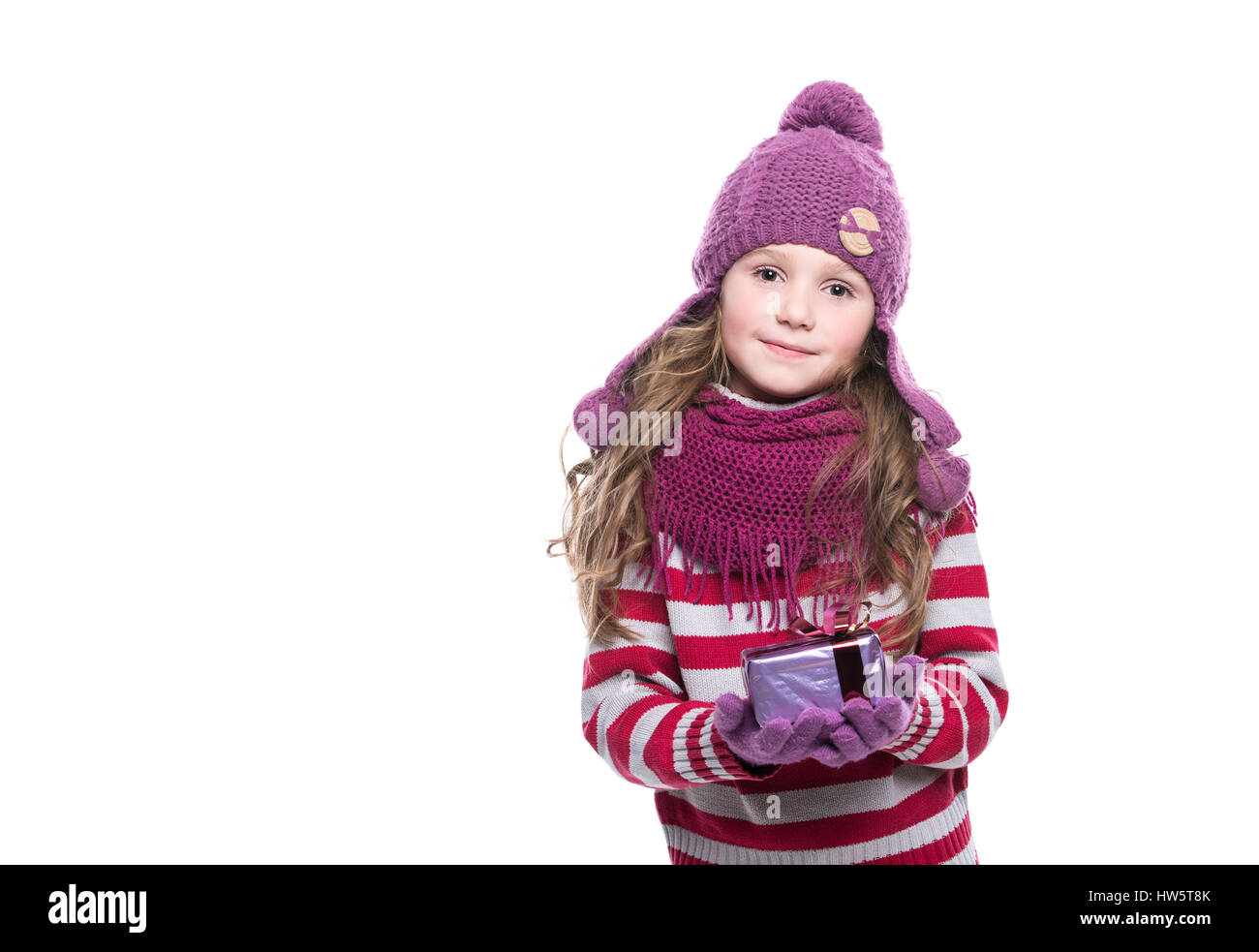 Niña vestidos vivamente en una sudadera rosa, sombrero, guantes, bufanda y  botas peludos, jugando en la nieve Fotografía de stock - Alamy
