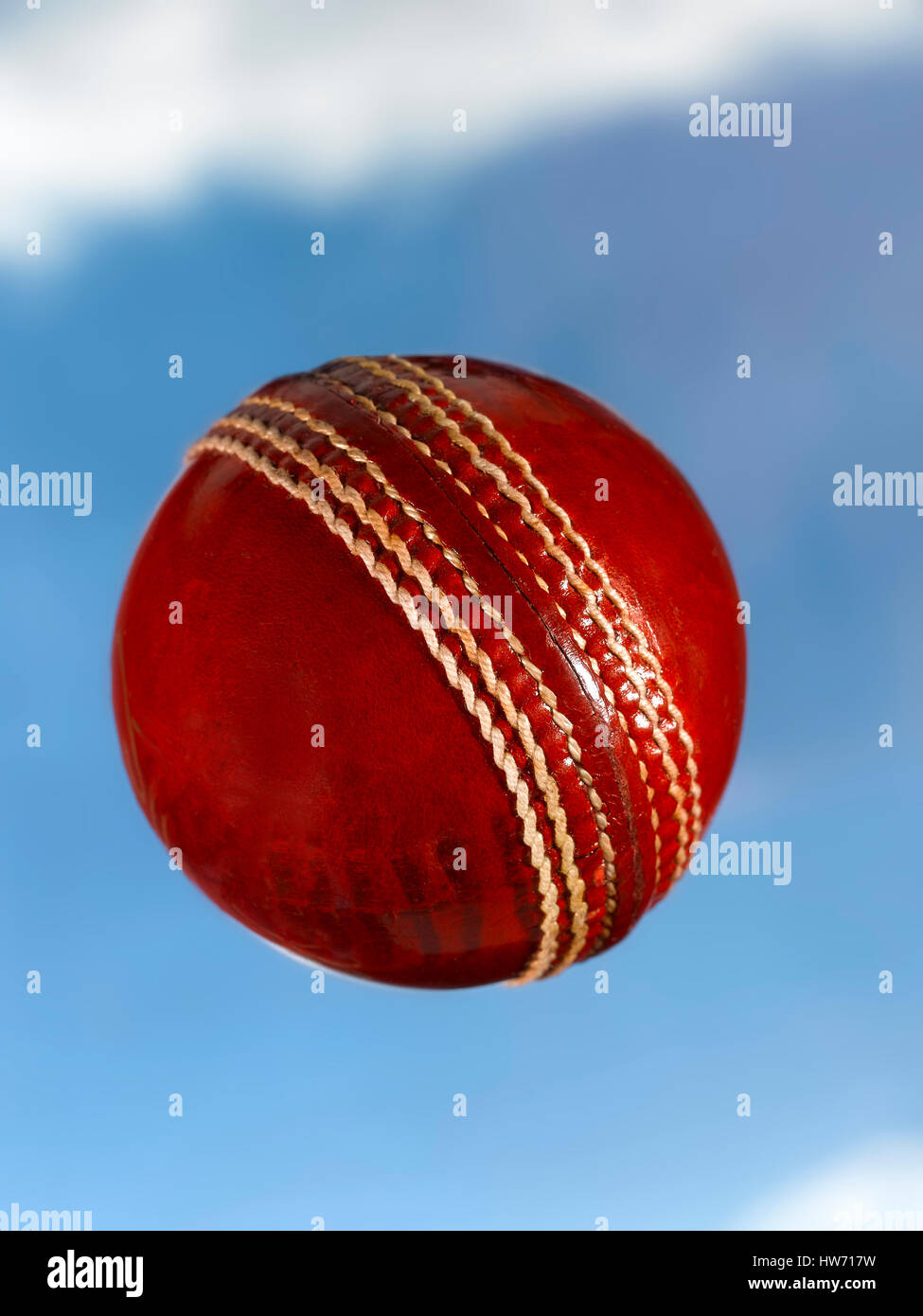 Bola de Cricket de cuero rojo volando a través del cielo Foto de stock
