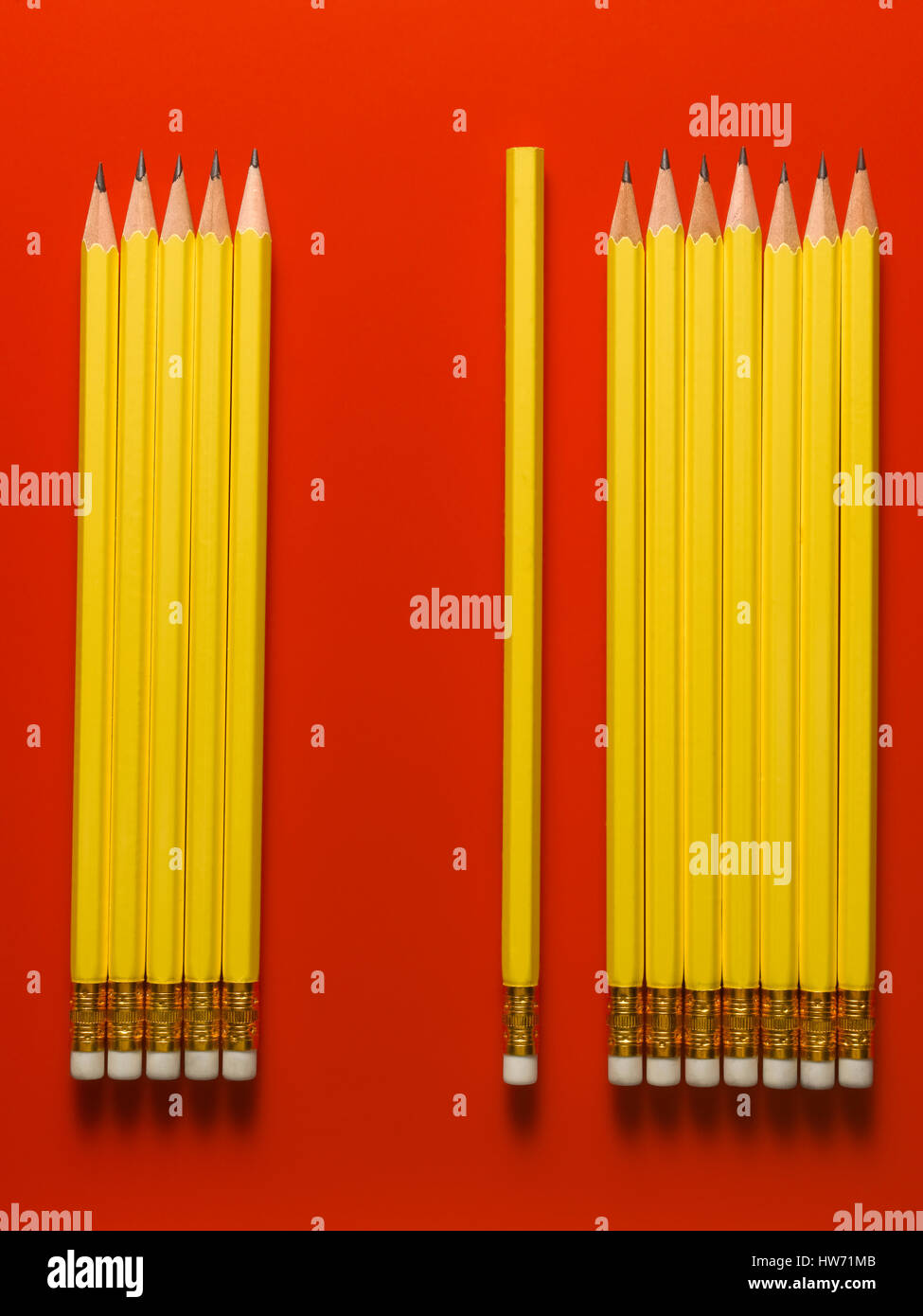 Lápiz amarillo aislado sobre un fondo rojo. Foto de stock