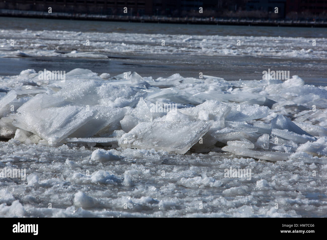 Congelados, nevado bloques de hielo flotando río abajo en una fría tarde de invierno Foto de stock