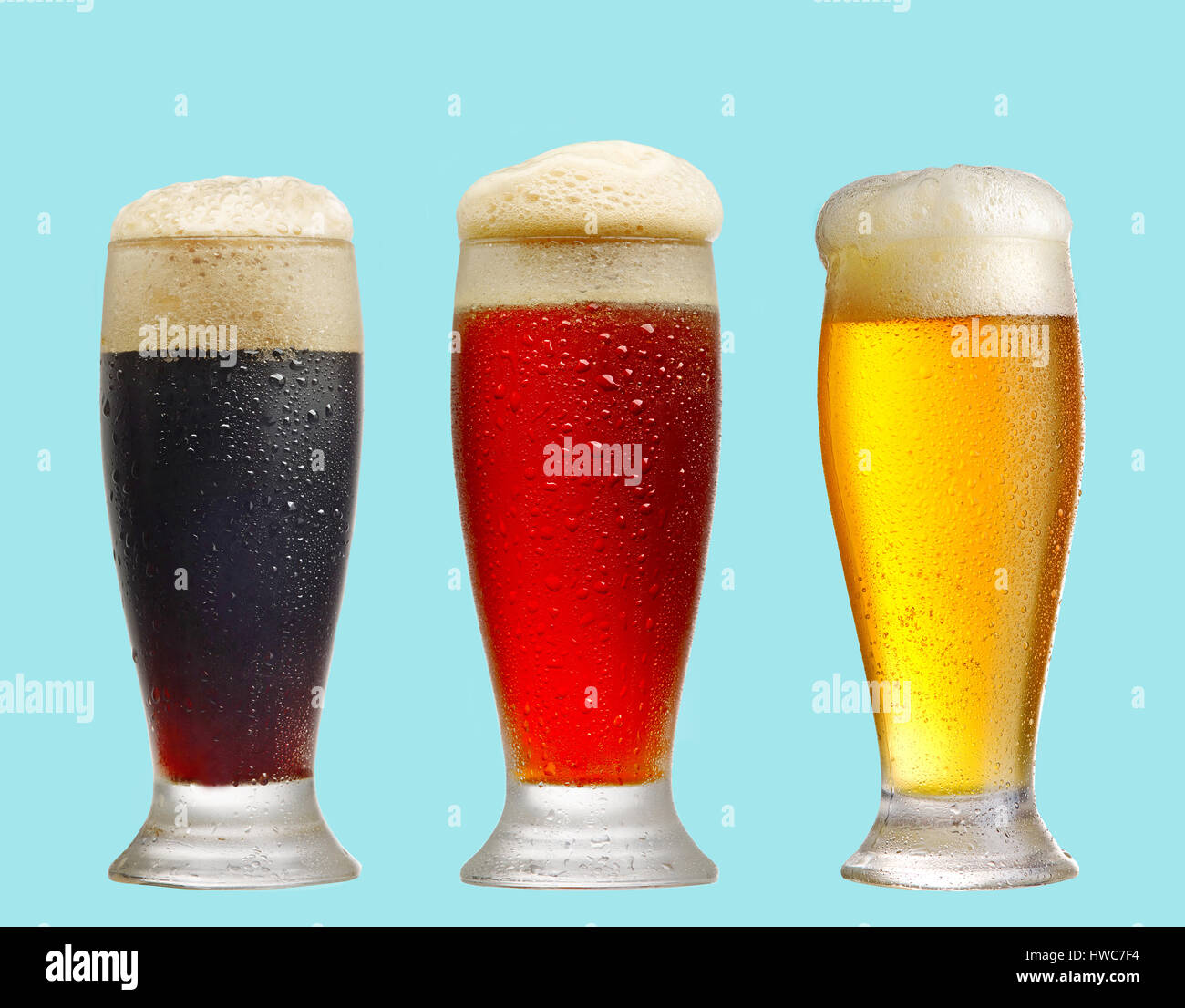 La luz roja, y los vasos de cerveza oscura sobre fondo azul. Foto de stock
