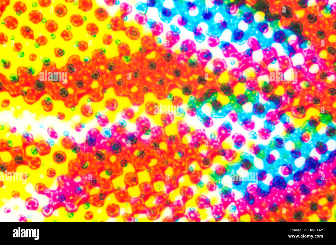 Impresión de cuatro colores en una superficie de plástico bajo el microscopio. CMYK Cyan Magenta Amarillo y negro o color. La mezcla sustractiva de color. Foto de stock