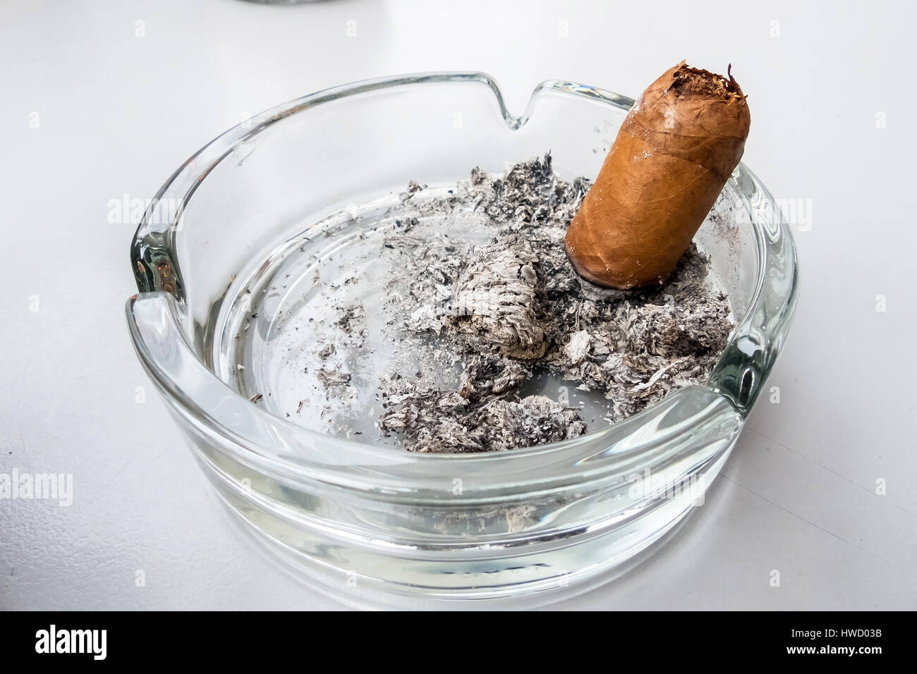 Casi listo fumado puro en un cenicero de cristal, Eine Zigarre fast fertig gerauchte en einem Aschenbecher aus Glas Foto de stock