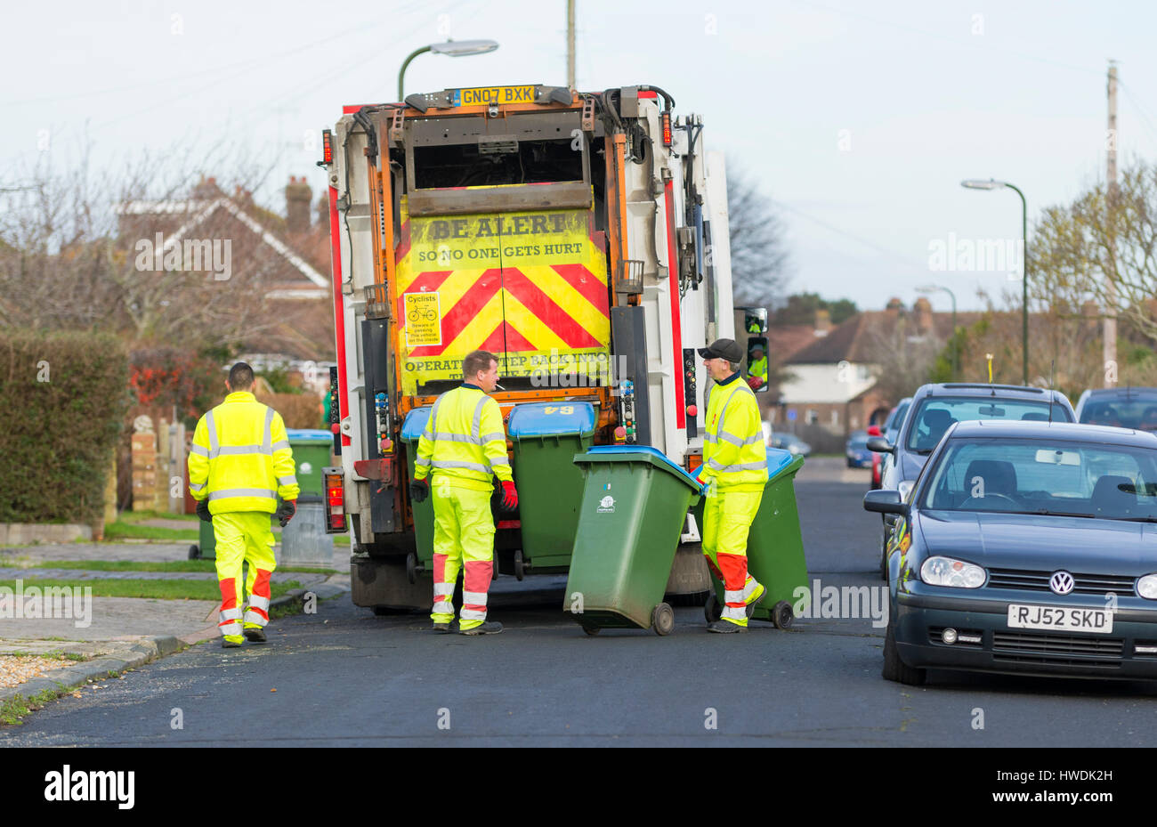 Varios dustmen con dustcart recogiendo basura en la bandeja del día en el sur de Inglaterra, Reino Unido. Foto de stock