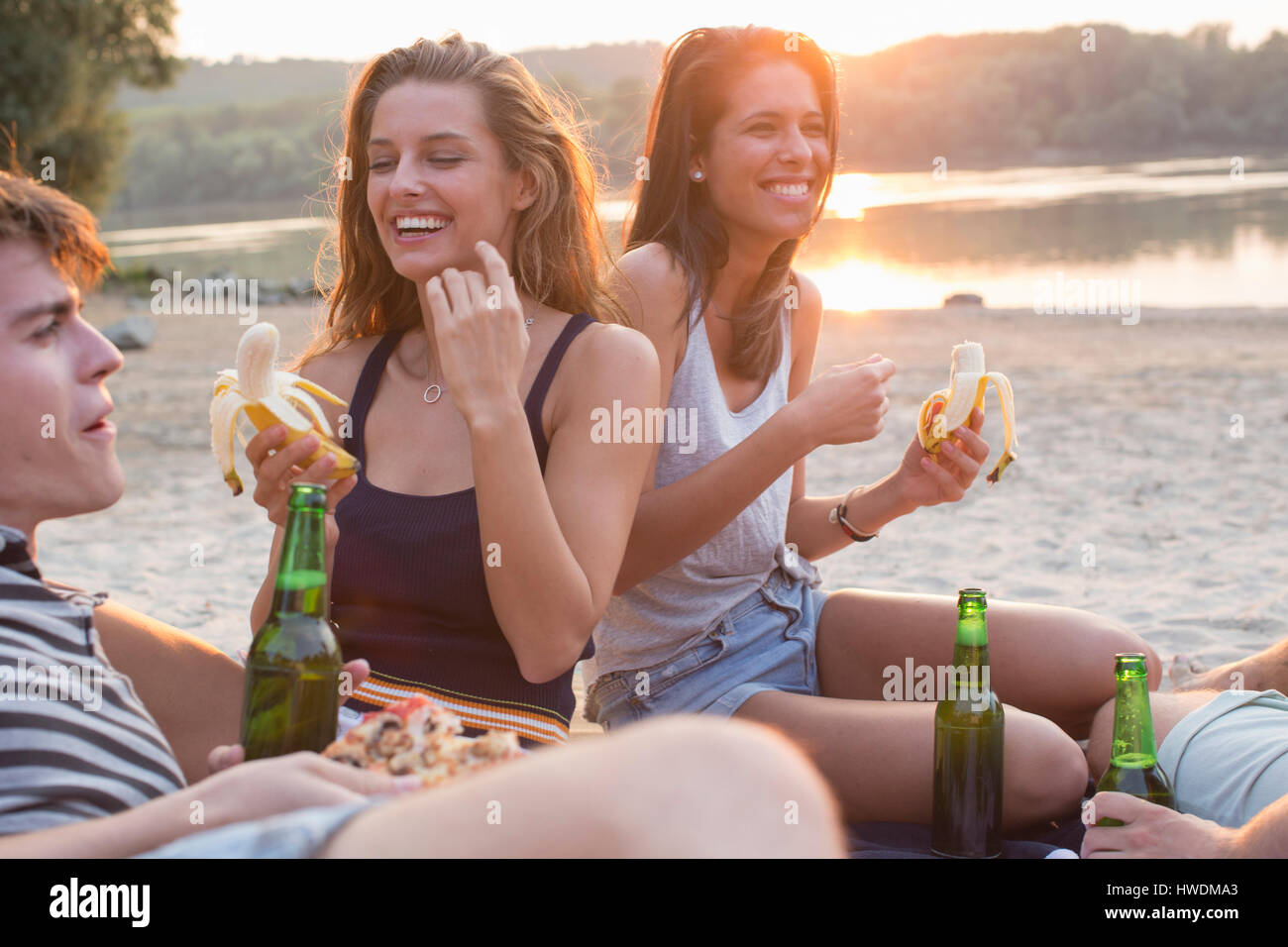 Un grupo de amigos, beber, disfrutar de las fiestas en la playa Foto de stock