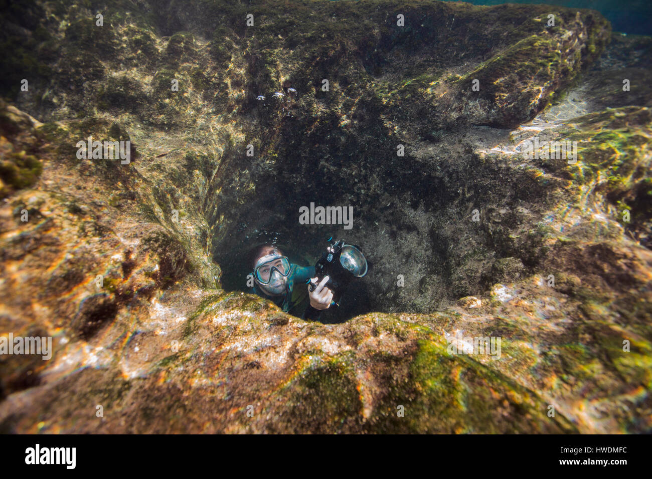 Hombre en cueva submarina con cámara Foto de stock