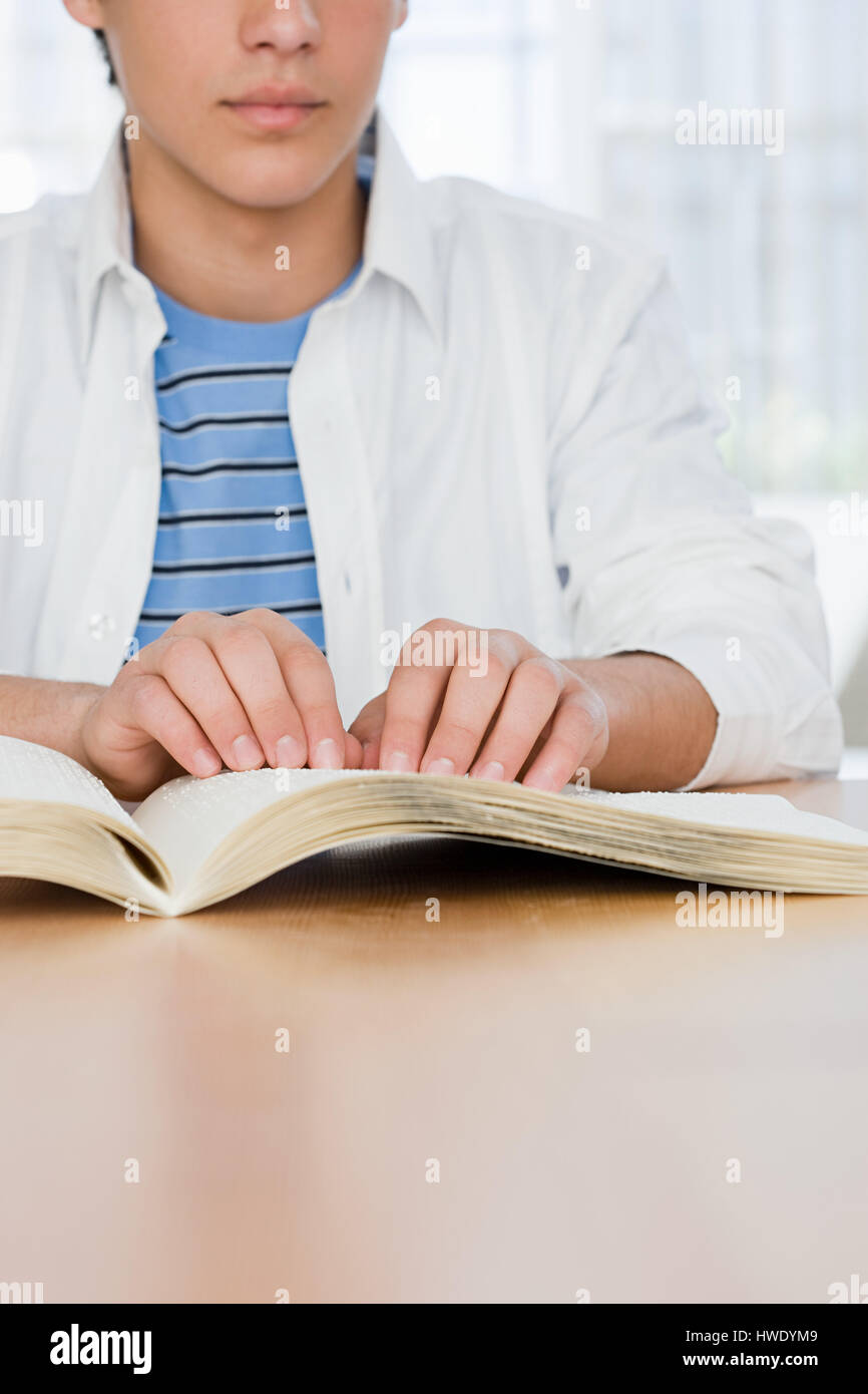 Muchacho ciego leyendo un libro en braille Foto de stock