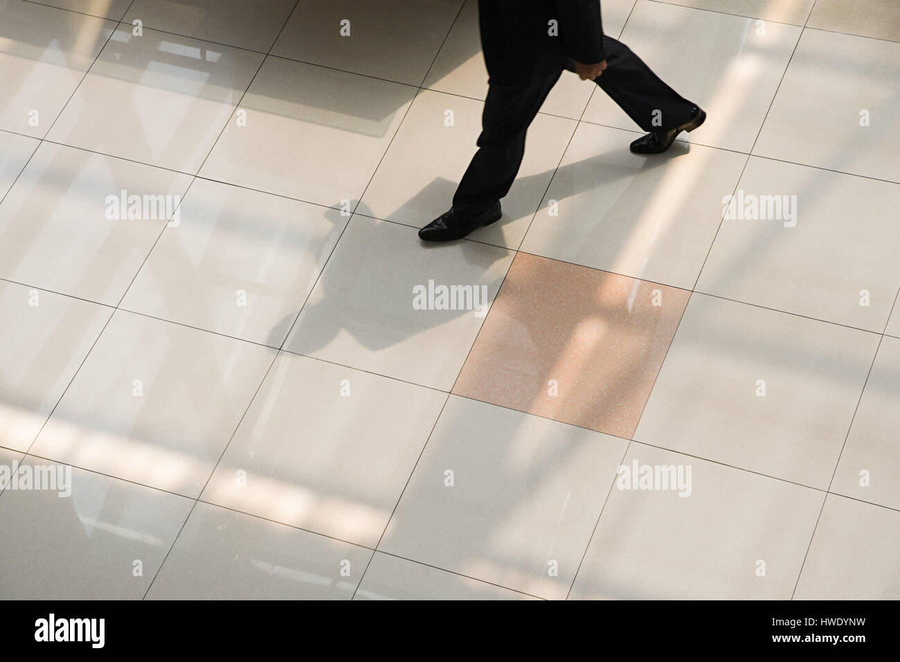 Empresario caminando en el piso de baldosas. Foto de stock