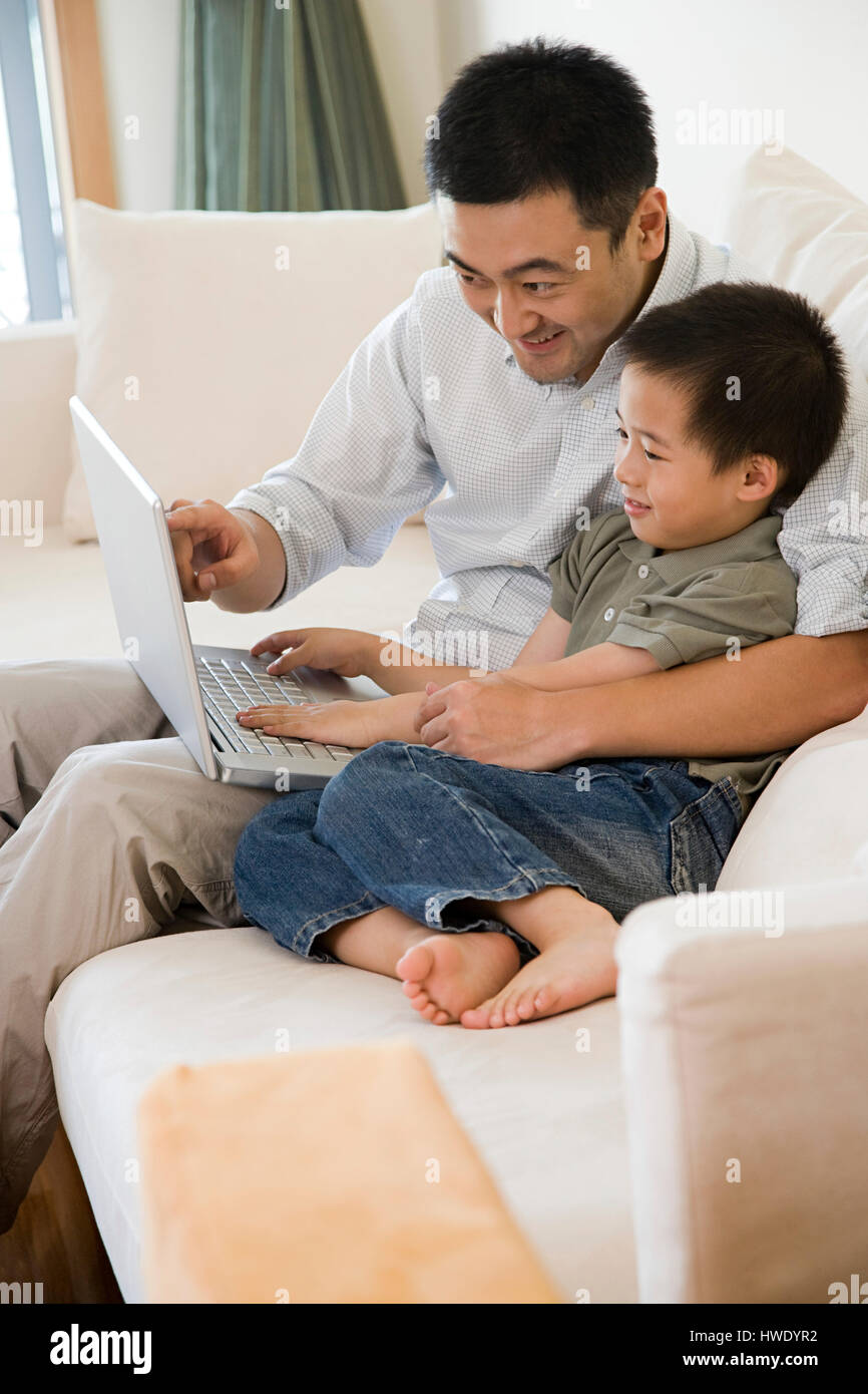 Padre e hijo utilizando un ordenador portátil Foto de stock