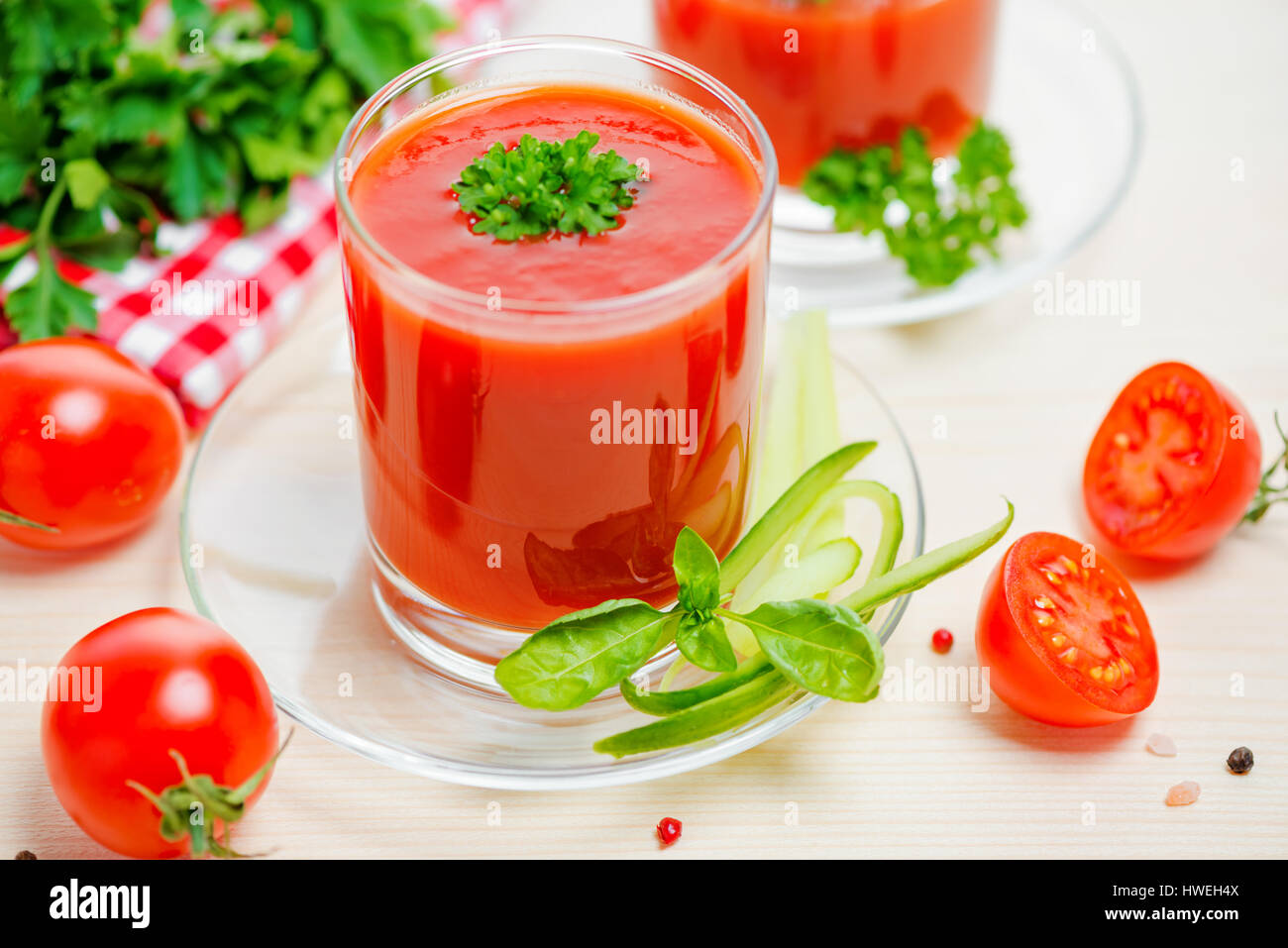 El jugo de tomate en vidrios transparentes con perejil y pepino en la mesa,  cerrar Fotografía de stock - Alamy