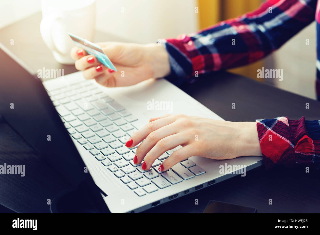 Mujer con portátil para realizar el pago en línea con tarjeta de crédito Foto de stock