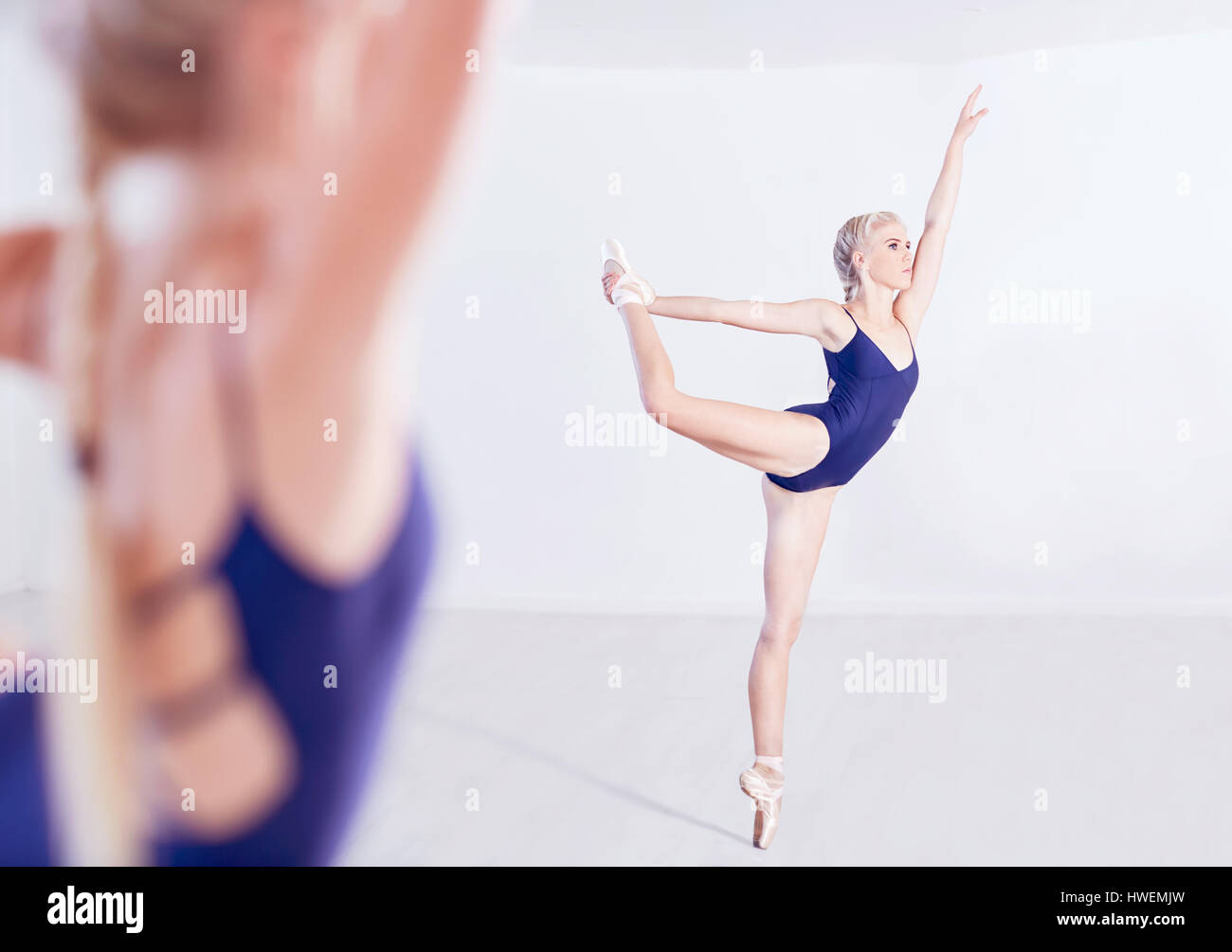 Imagen de espejo de la joven bailarina de ballet en Pointe en dance studio Foto de stock