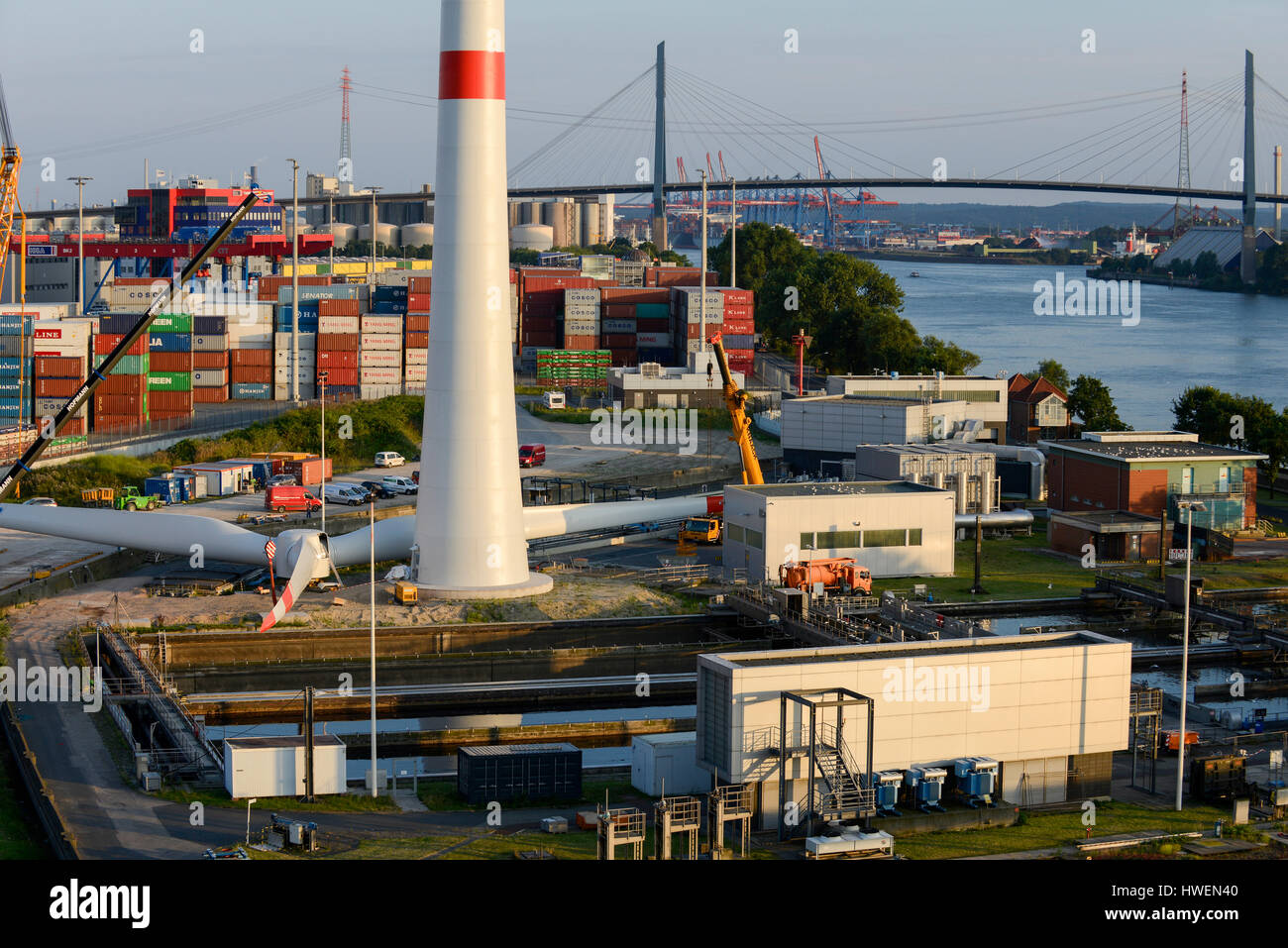 Alemania Hamburgo, construcción de nuevas turbinas eólicas Nordex en la planta de tratamiento de Hamburg Wasser, el proveedor local de agua, detrás y el río Elba Suederelbe Koehlbrandbruecke Foto de stock