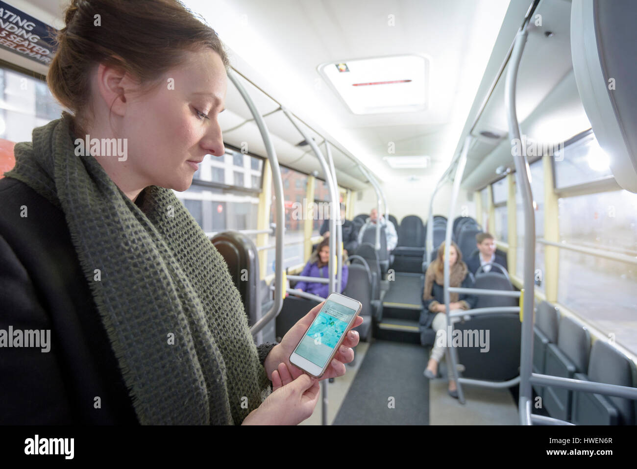 Pasajero que usa el smartphone a ver mapa en autobús eléctrico Foto de stock