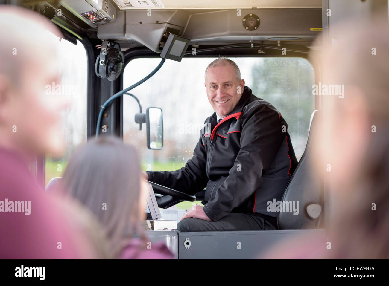 Retrato del conductor de autobús con el embarque a los pasajeros de autobús eléctrico Foto de stock