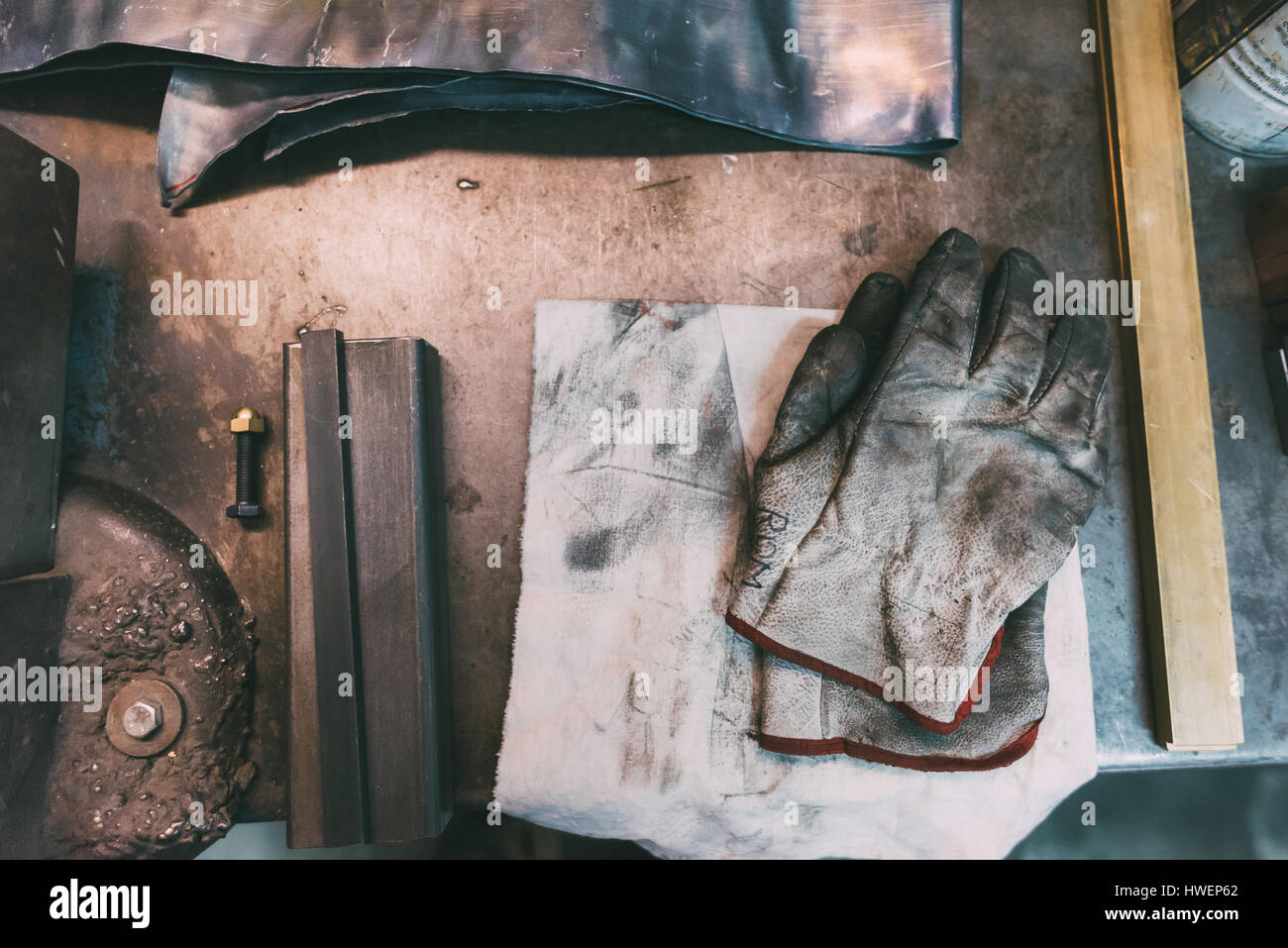 Vista aérea de metales y guantes protectores en la Forge workbench Foto de stock