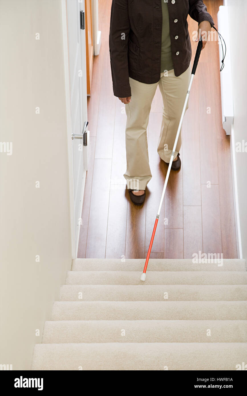 Mujer ciega usando un bastón de escalera Foto de stock