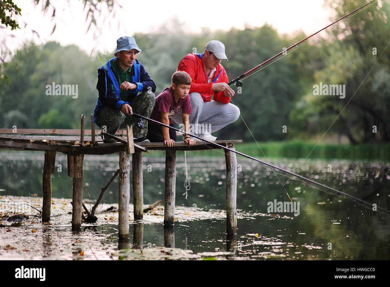 Dos pescadores pescar de pie en el puente Foto de stock