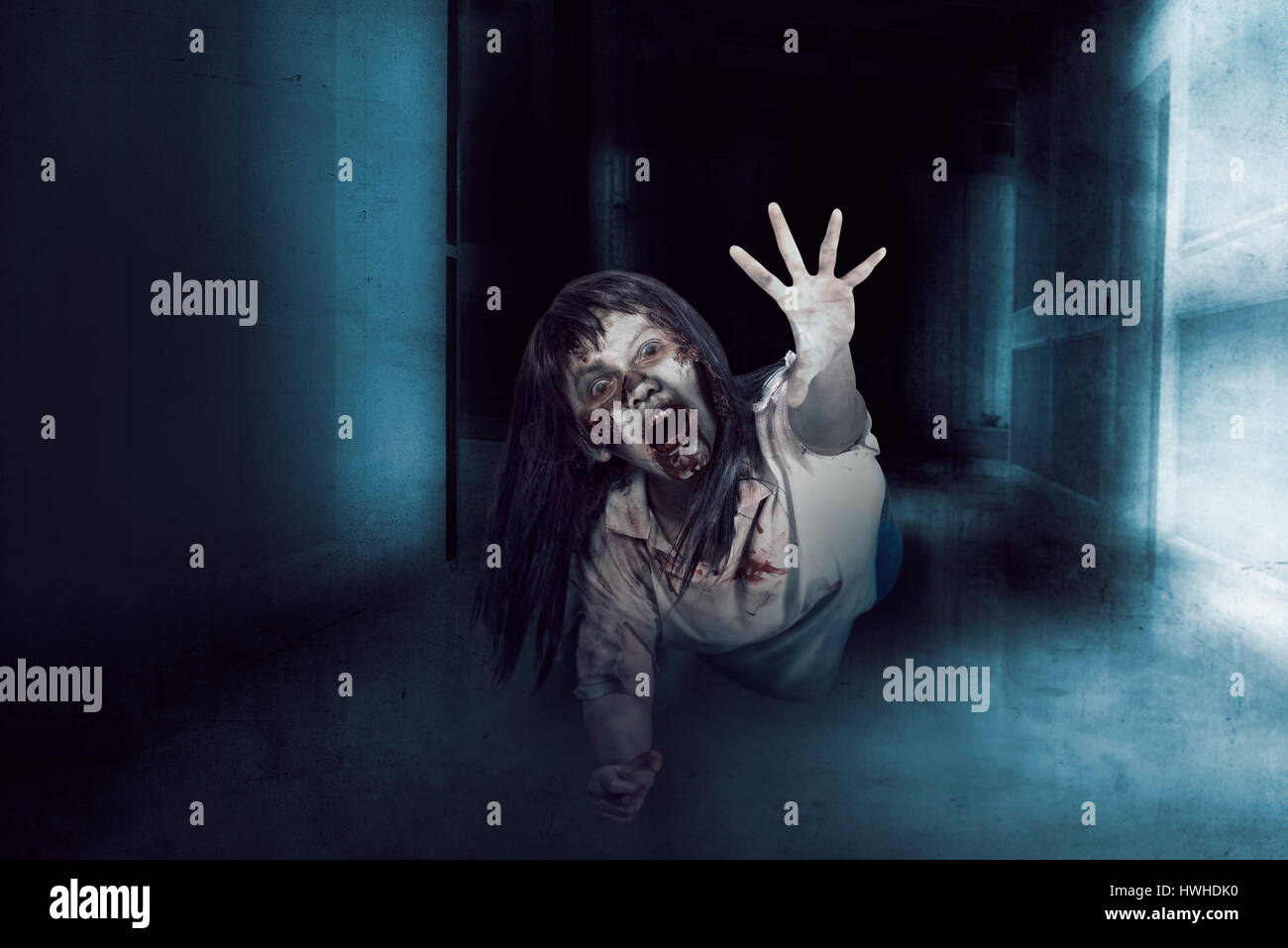 Asia mujer zombie, fea cara y expresión de ira en la habitación vacía, el horror de la situación. Foto de stock