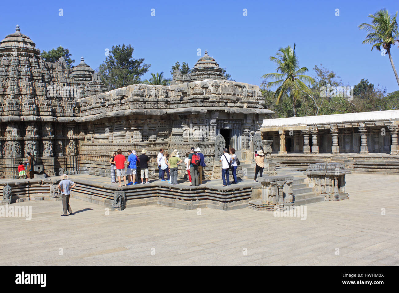 Los turistas admirando las esculturas de piedra de los principales santuarios en el templo Chennakesava, arquitectura de Hoysala, Somnathpur, Karnataka, India Foto de stock