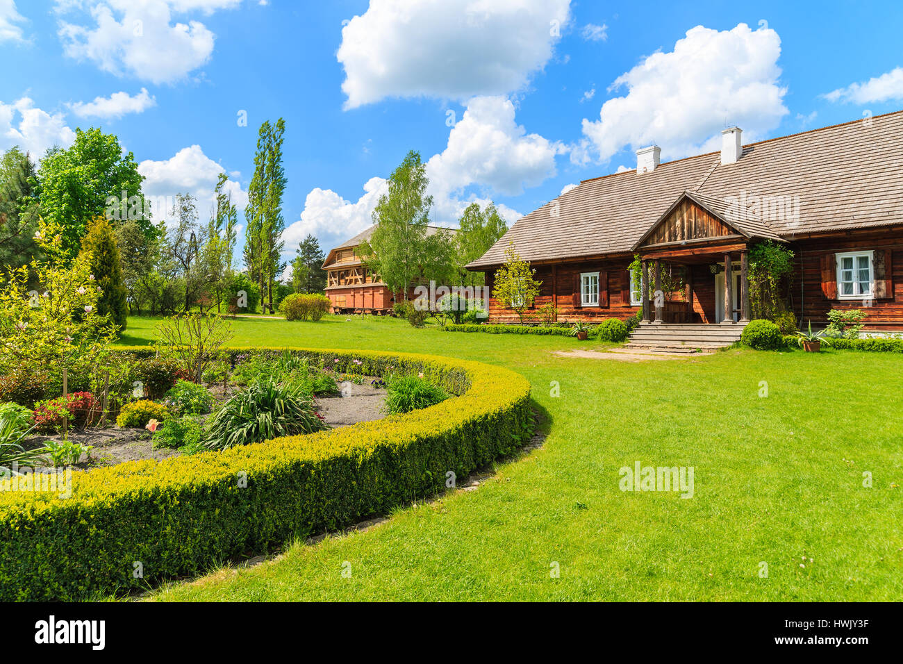 Antigua casa solariega tradicional y hermoso jardín en Tokarnia Village en el soleado día de primavera, Polonia Foto de stock