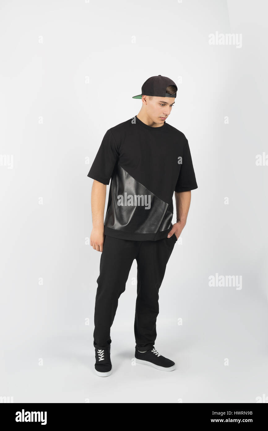 Musculoso joven hombre vestido con ropa negra y con snapback sneakers  aislado sobre fondo blanco Fotografía de stock - Alamy