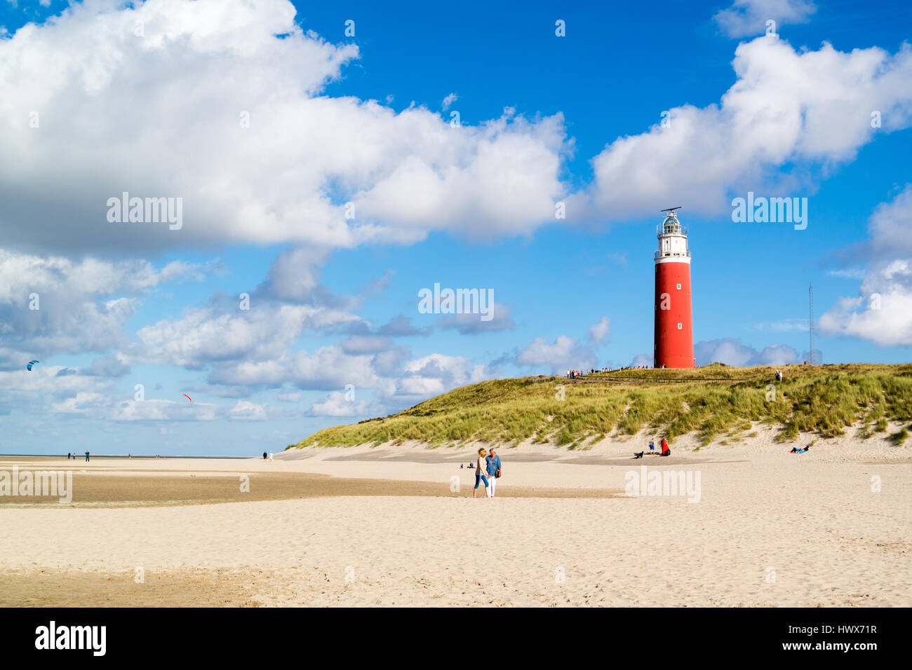 Playa con la gente y el faro de De Cocksdorp en la isla Texel, Holanda Septentrional, Holanda Foto de stock