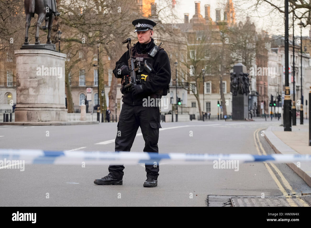 Un oficial de armas de fuego de la policía metropolitana está en guardia en Whitehall, tras un ataque terrorista en el Palacio de Westminster en marzo de 2017. Foto de stock