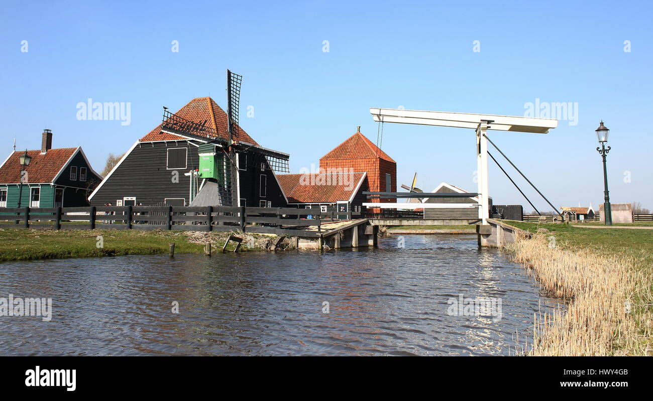 El molino de viento, el puente levadizo de madera y las tradicionales casas holandesas en el museo al aire libre de Zaanse Schans, Zaandam / Zaandijk, Países Bajos Foto de stock