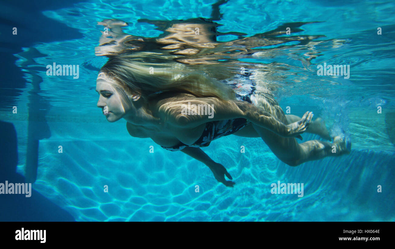 Vista submarina de mujer en bikini nadar en piscina Foto de stock