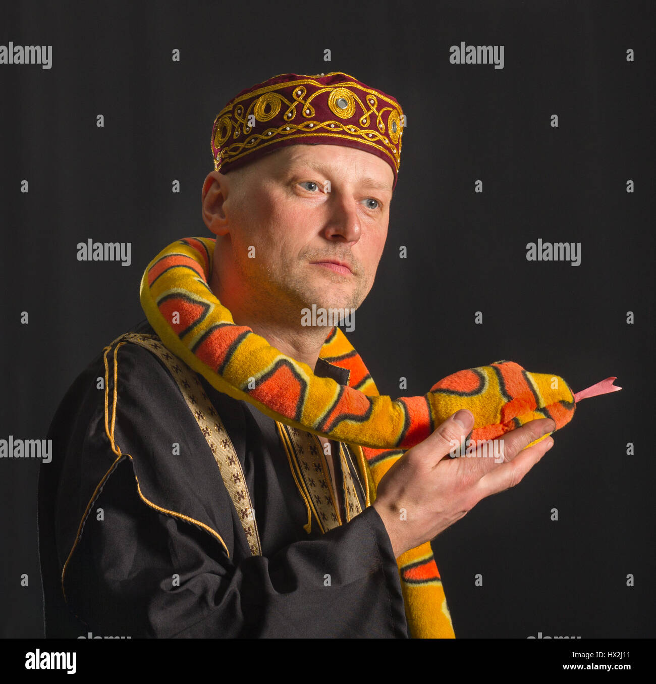 Actor con juguete serpiente sobre un fondo negro. Foto de stock