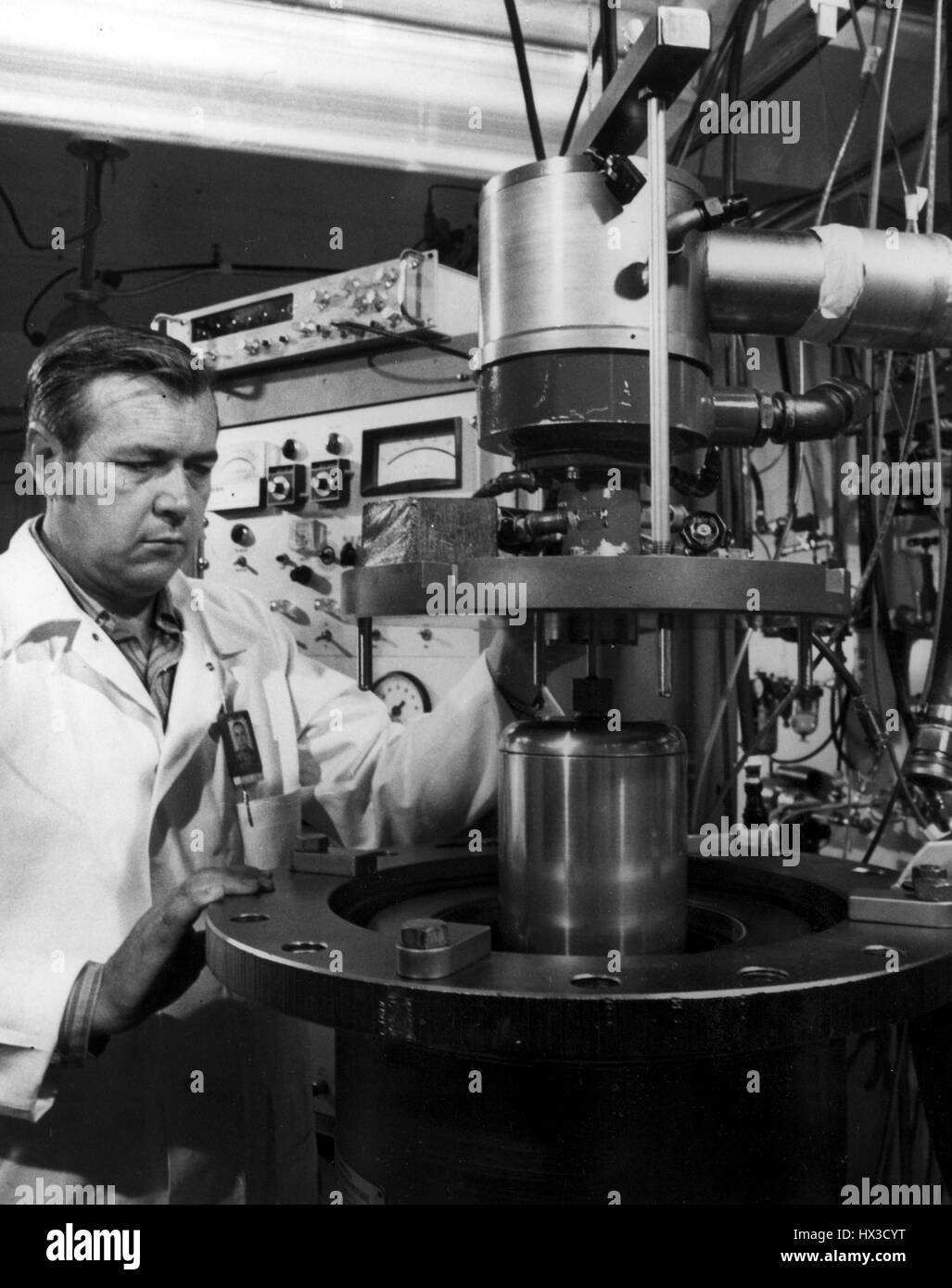 Un hombre en una bata de laboratorio interactúa con un líquido centrífuga zonal que fue desarrollado por la Comisión de Energía Atómica de Estados Unidos en Oak Ridge National Laboratory, Oak Ridge, Tennessee, 1972. Imagen cortesía del Departamento de Energía de Estados Unidos. Foto de stock