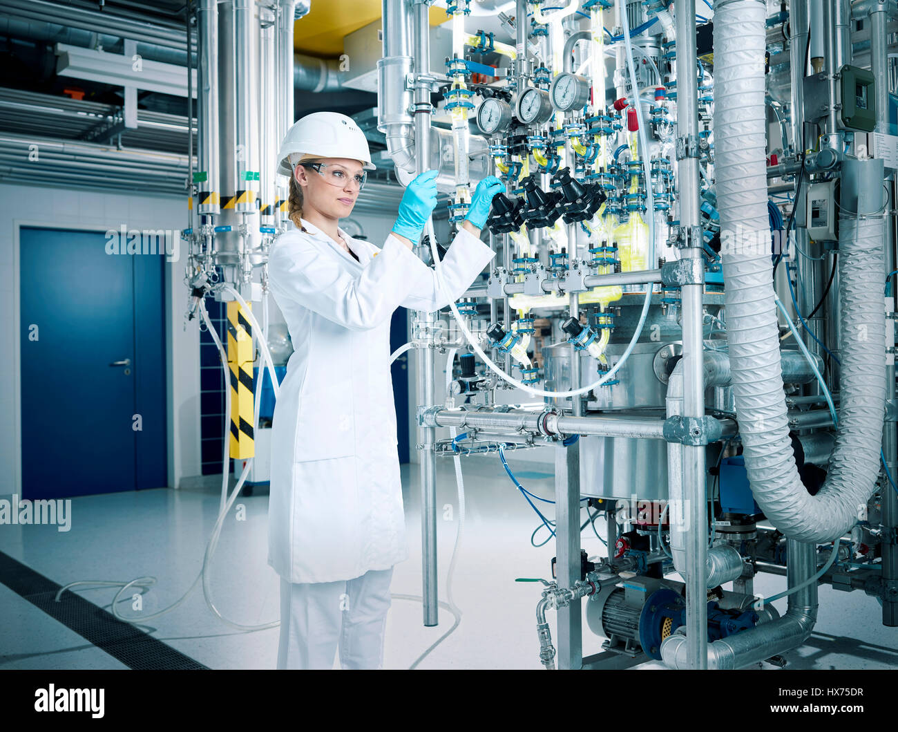 Chemielaborantin, químico con casco y gafas en la producción farmacéutica, Austria Foto de stock