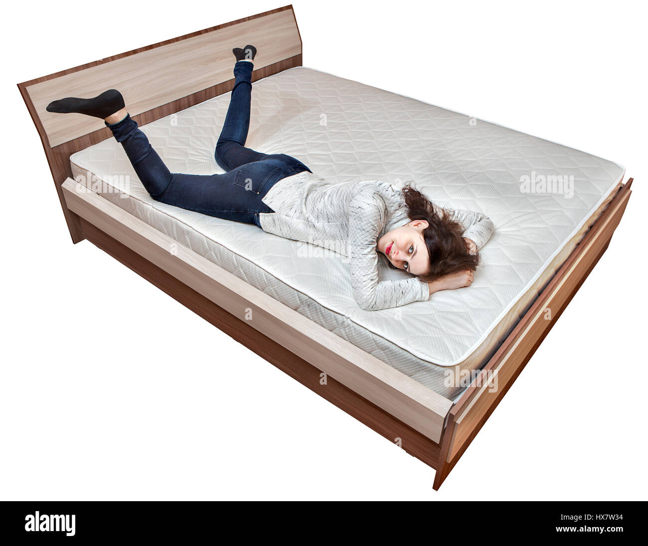 Una joven muchacha caucásica descansa sobre un colchón de la cama catre de  madera aislado sobre fondo blanco Fotografía de stock - Alamy