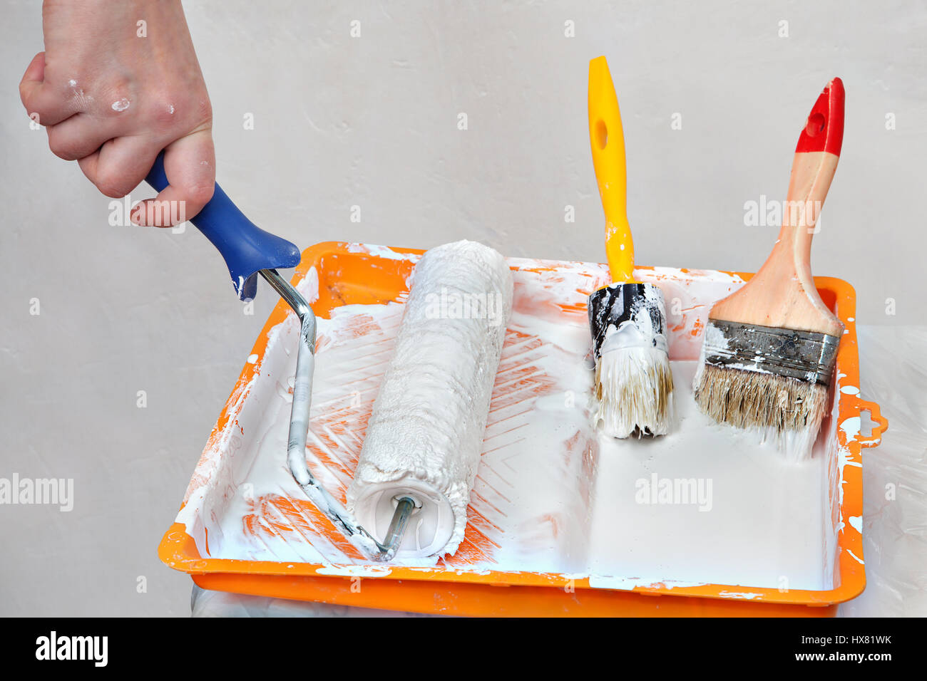 Utensilios para pintar la casa, pintor herramientas en una bandeja naranja  con pintura blanca, cepillo y pinceles Fotografía de stock - Alamy