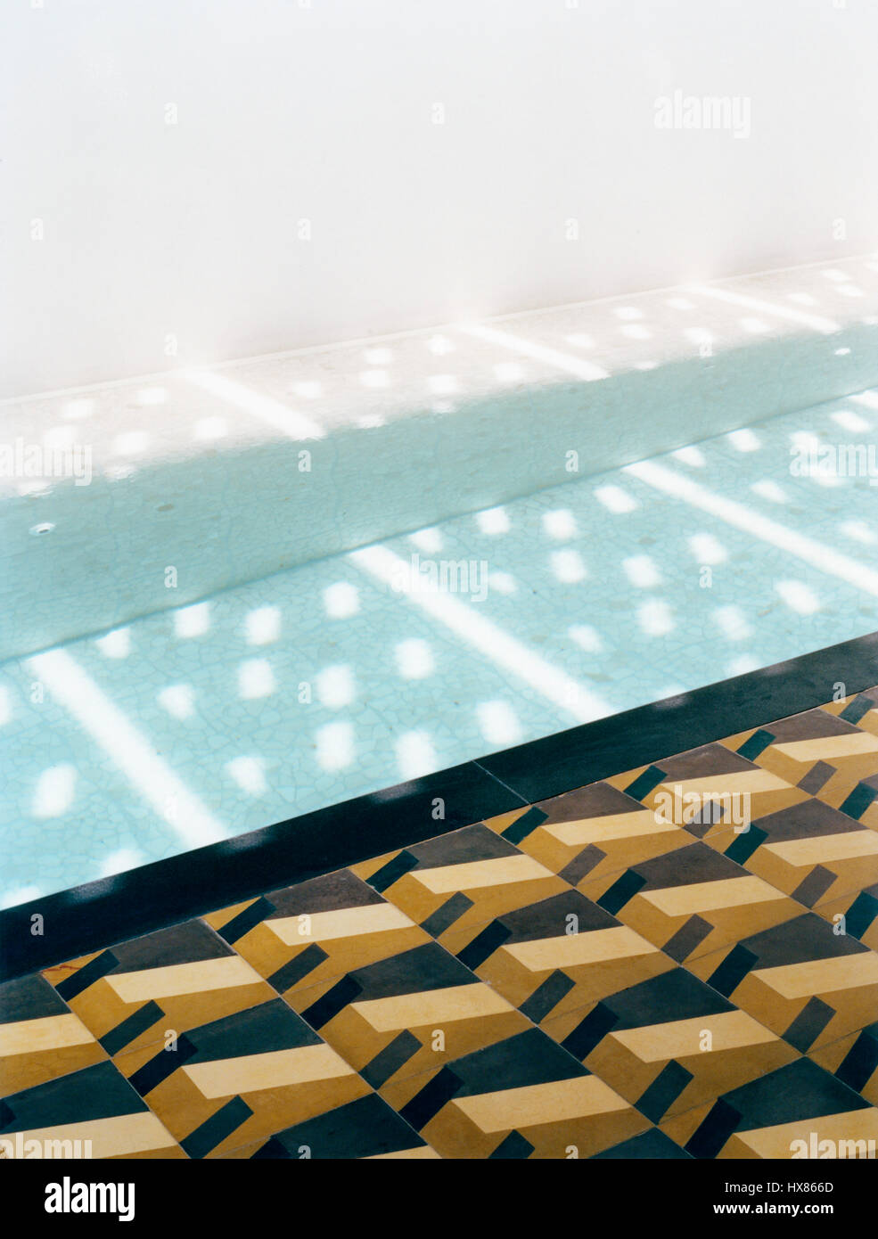 Detalle de los mosaicos del piso y la luz del sol a través de las pantallas de GRC se refleja en la piscina. Casa Delpin, San Juan, Puerto Rico. Arquitecto: Nataniel Fuster, 2006. Foto de stock