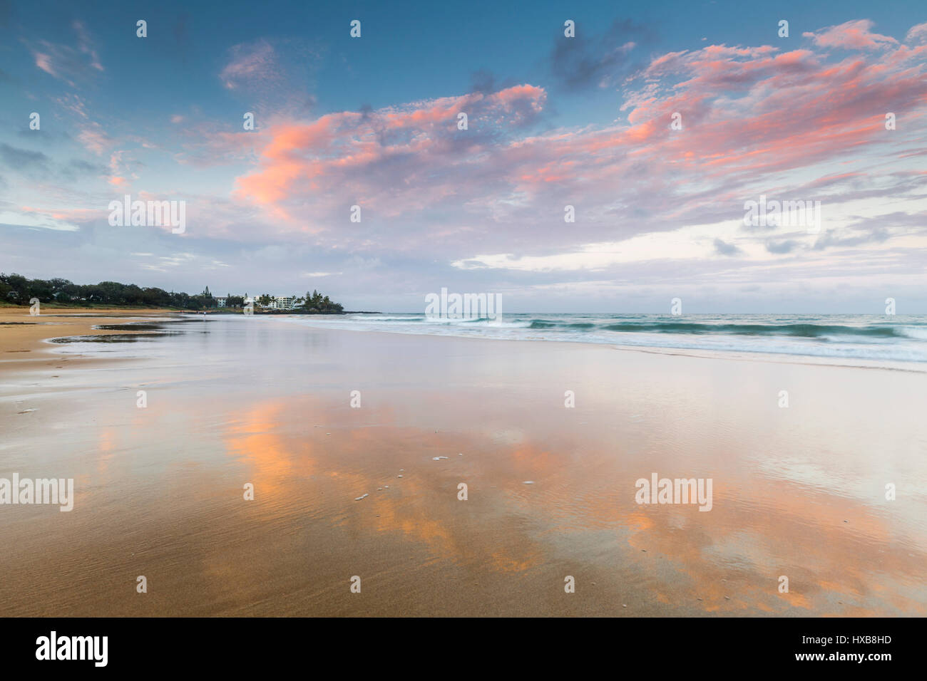 Vista a lo largo de la arena de playa al atardecer Bargara, Bundaberg, Queensland, Australia Foto de stock