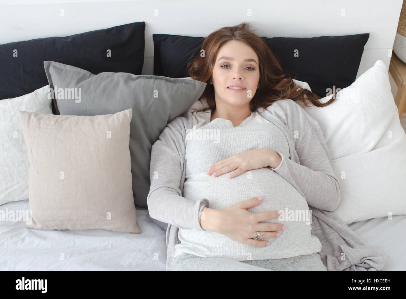 Mujeres embarazadas acostado en una cama Foto de stock