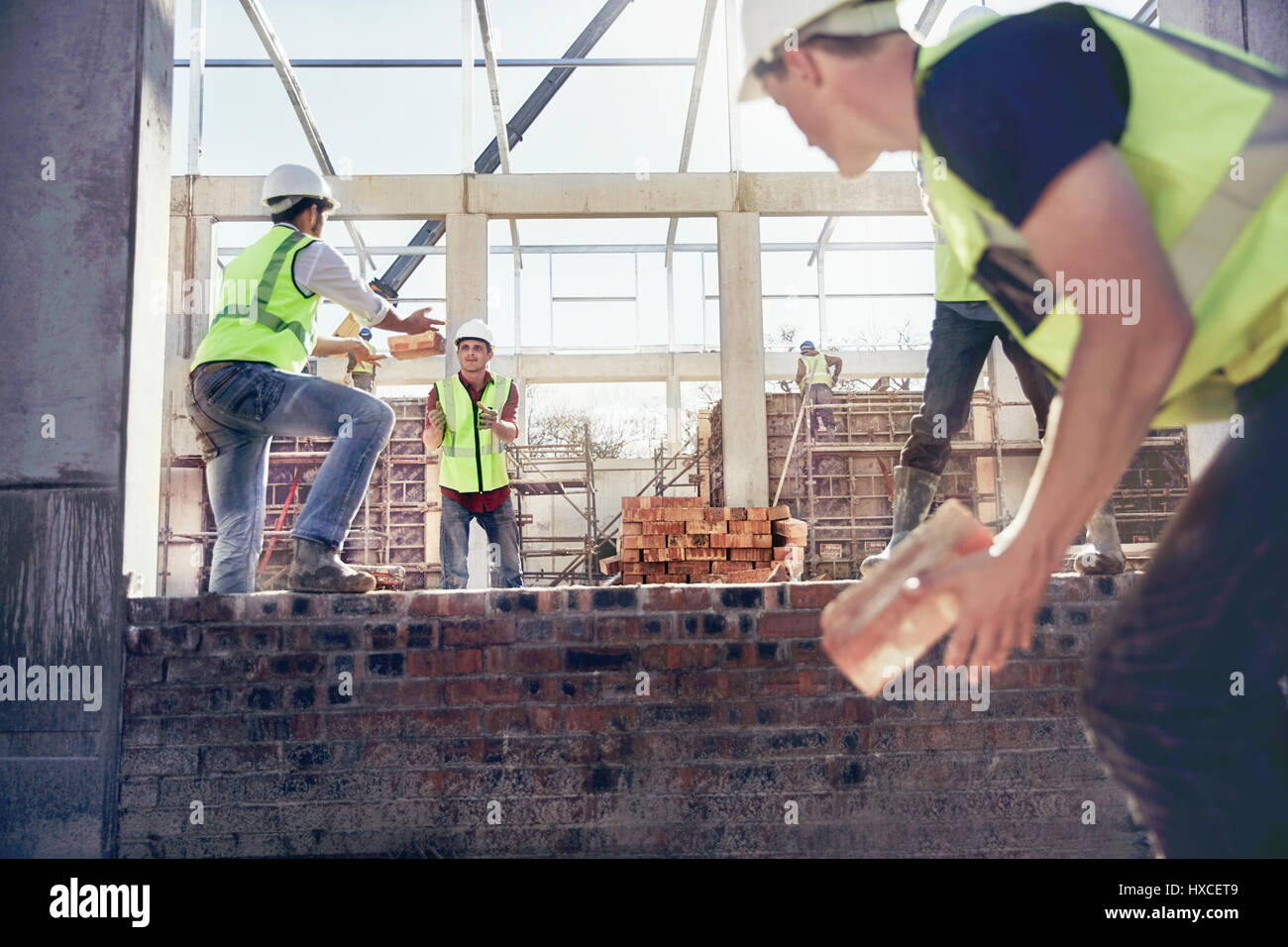 Los trabajadores de la construcción bricklaying en sitio en construcción Foto de stock